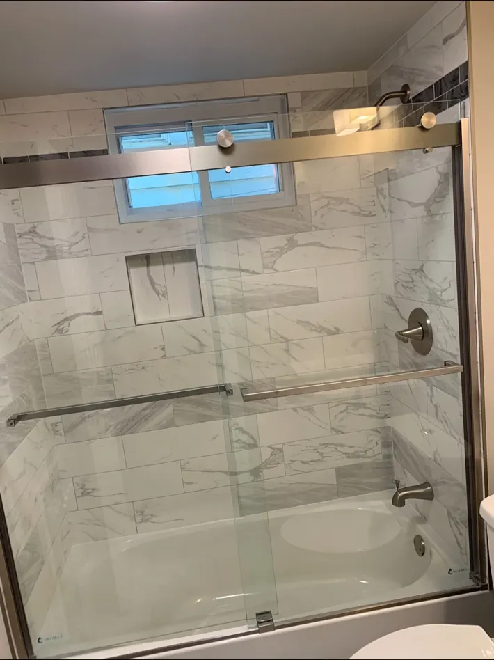 Finished bathroom with tiled tub surround and glass shower enclosure