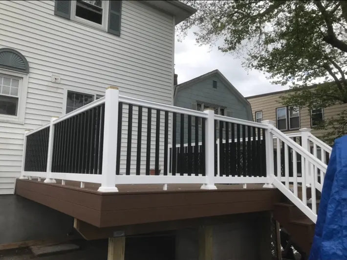 Completed raised deck with brown decking and white and black railings