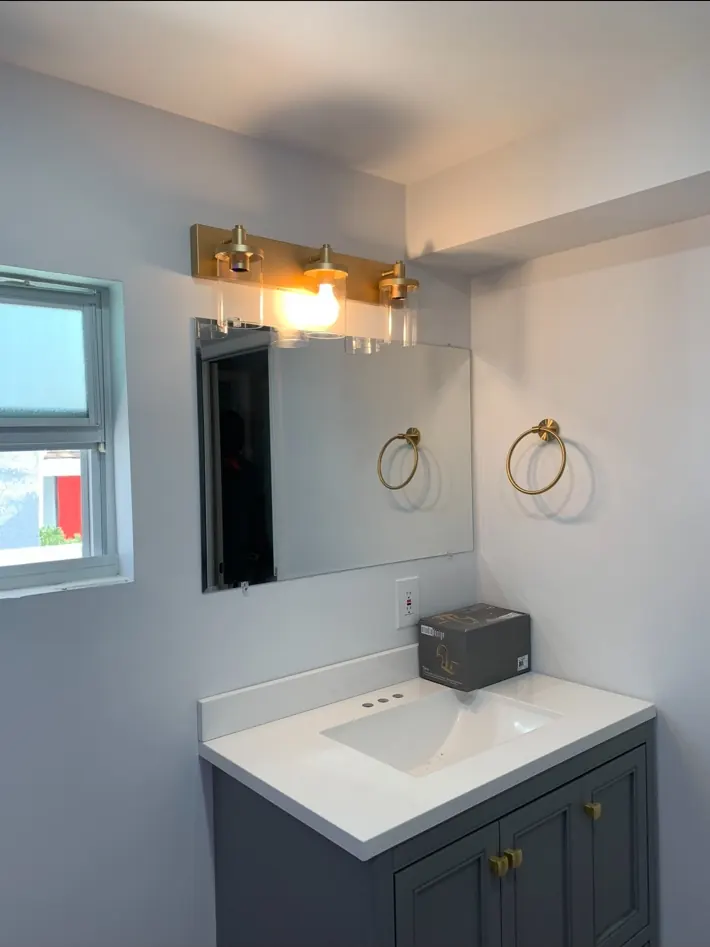Finished bathroom vanity, mirror, and lighting