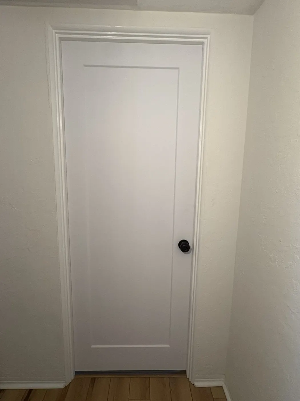 Finished shaker-style interior door installed with dark hardware