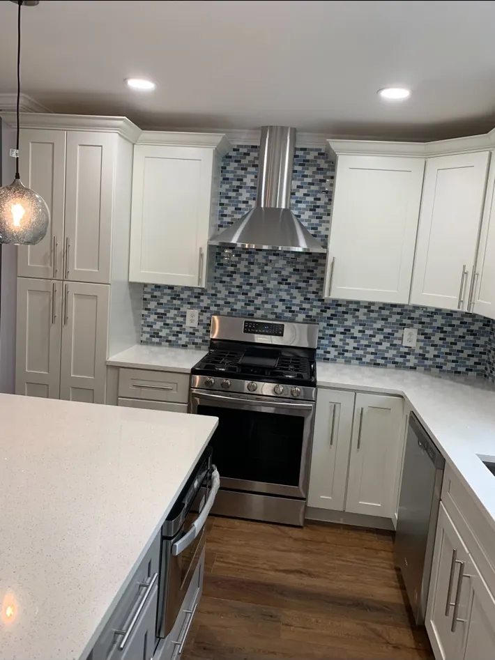 Finished kitchen range, hood, cabinetry, and backsplash