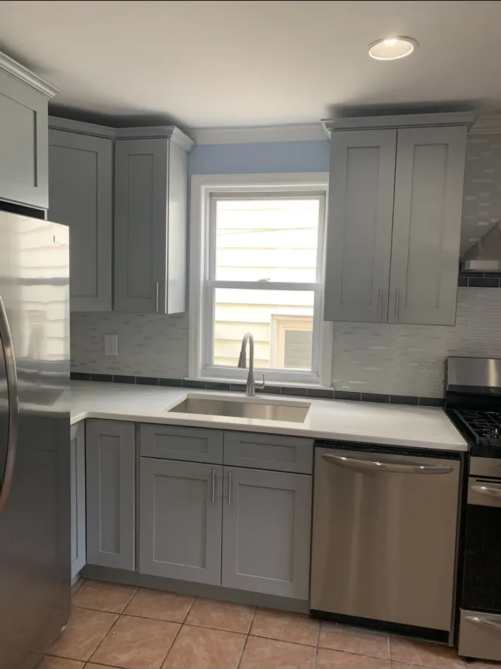 Finished kitchen cabinetry, sink, countertop, and backsplash
